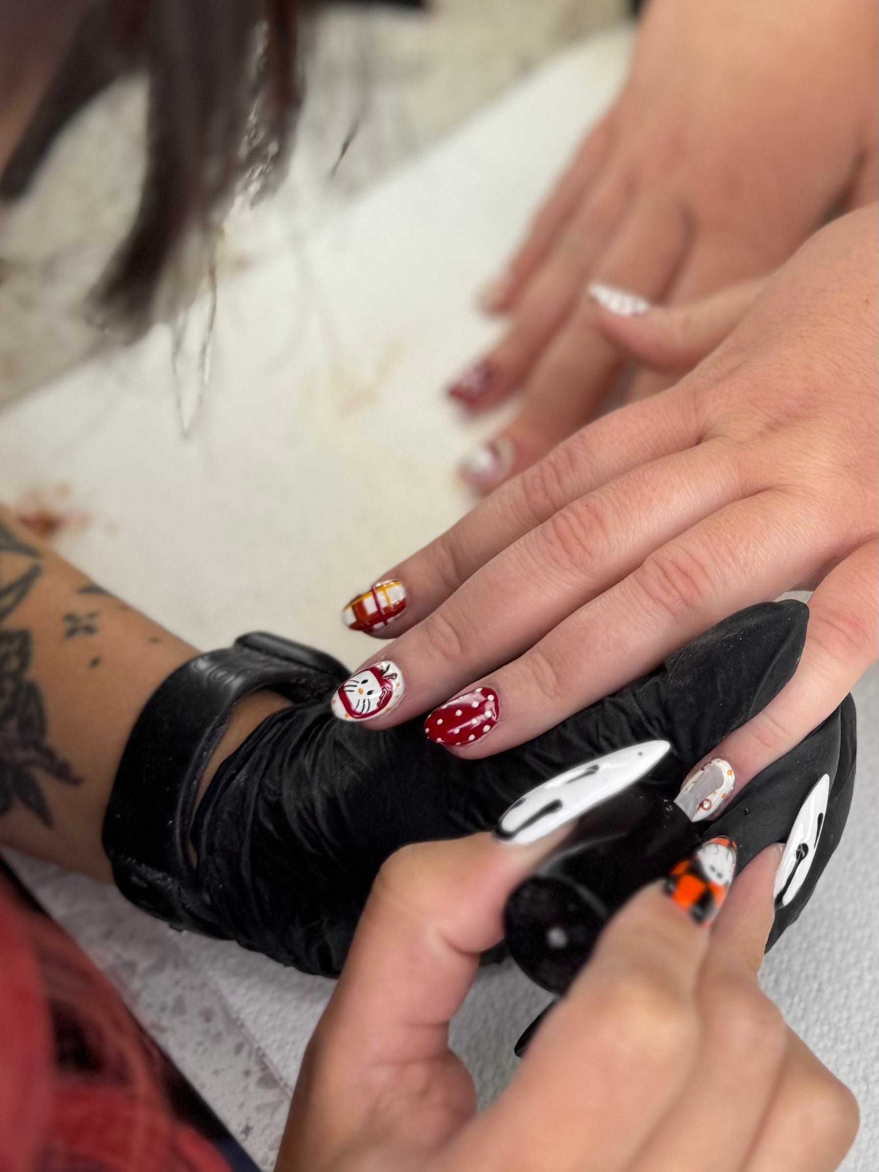 Nail artist painting festive designs on nails.